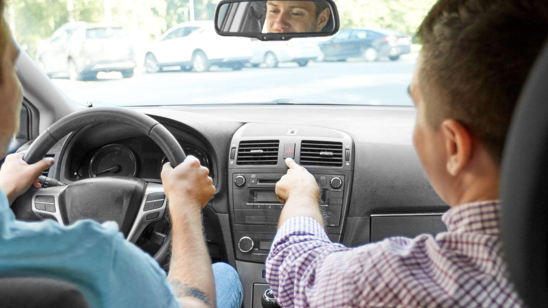 A learner driver sitting in a car with an instructor
