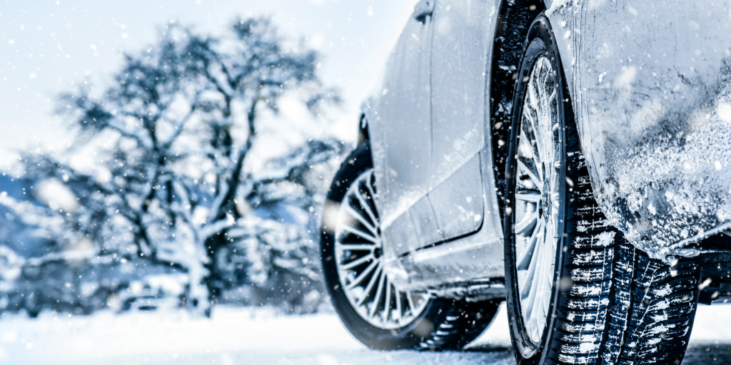 A car driving on a snow-covered Ontario road, highlighting winter safety essentials like snow tires and clear visibility.